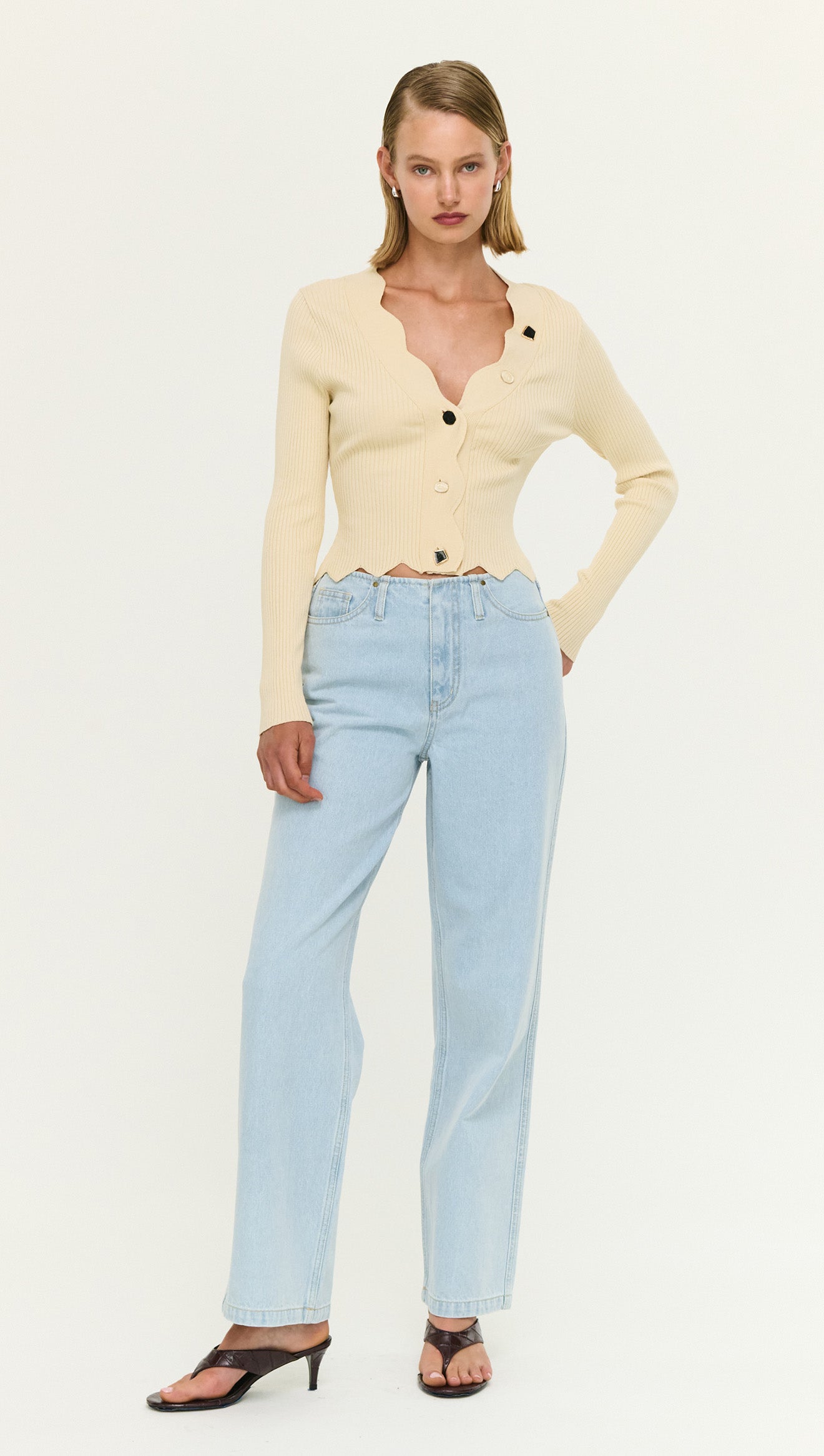 Ornate Button Scallop Neck Cardi in Yellow worn with light blue jeans, featuring buttons and scalloped edges for a feminine look.