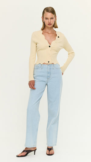 Ornate Button Scallop Neck Cardi in Yellow worn with light blue jeans and black heels, showcasing a stylish outfit.