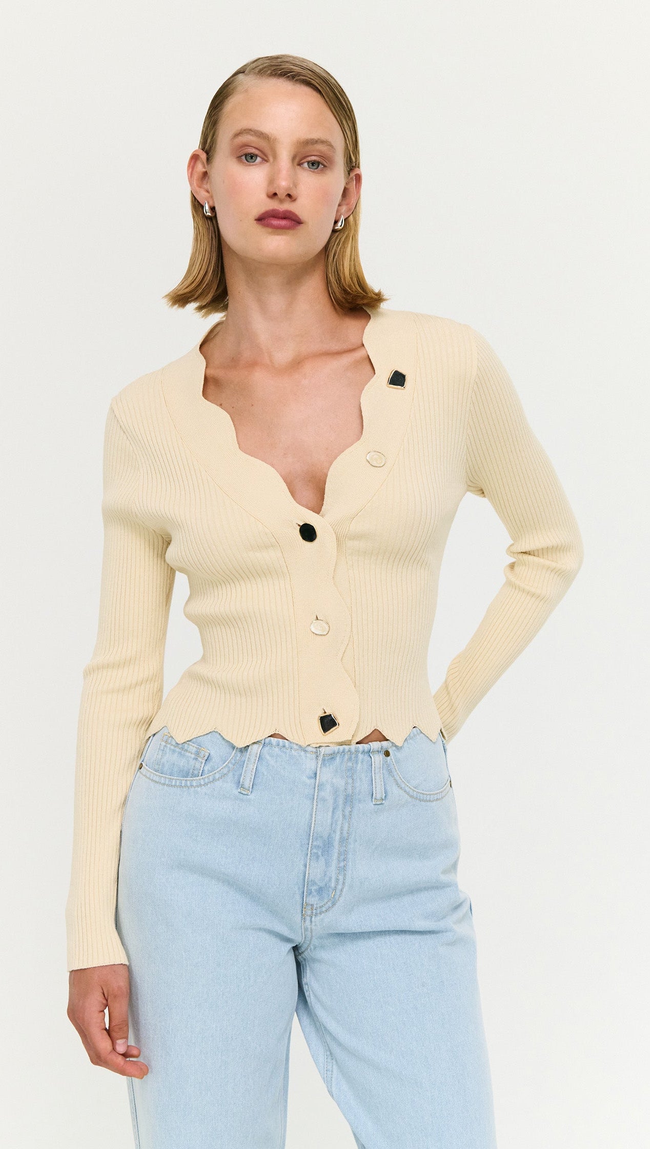 Ornate Button Scallop Neck Cardi in Yellow worn with light blue jeans, featuring buttons and scalloped edges for a feminine look.
