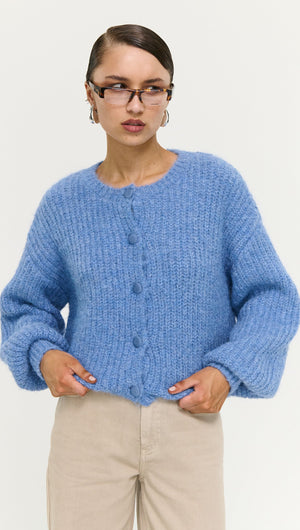 Soft Handle Ballon Sleeve Cardigan in Blue worn by a model, featuring fluffy texture and buttons, styled with beige pants.