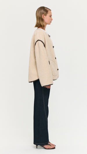 Brown Contrast Trim Duffle Coat in Teddy displayed on a model from the side view, showcasing its cozy design and style.