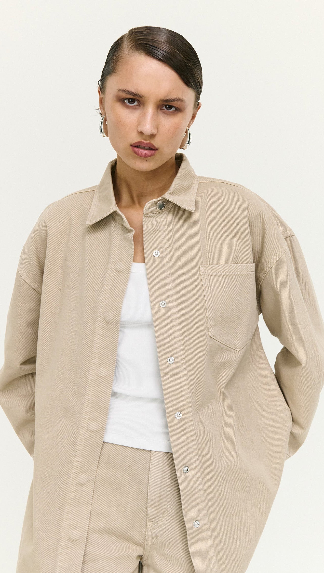 Stone Wash Relaxed Denim Shacket worn by a model, featuring a light beige color and relaxed fit, perfect for layering.