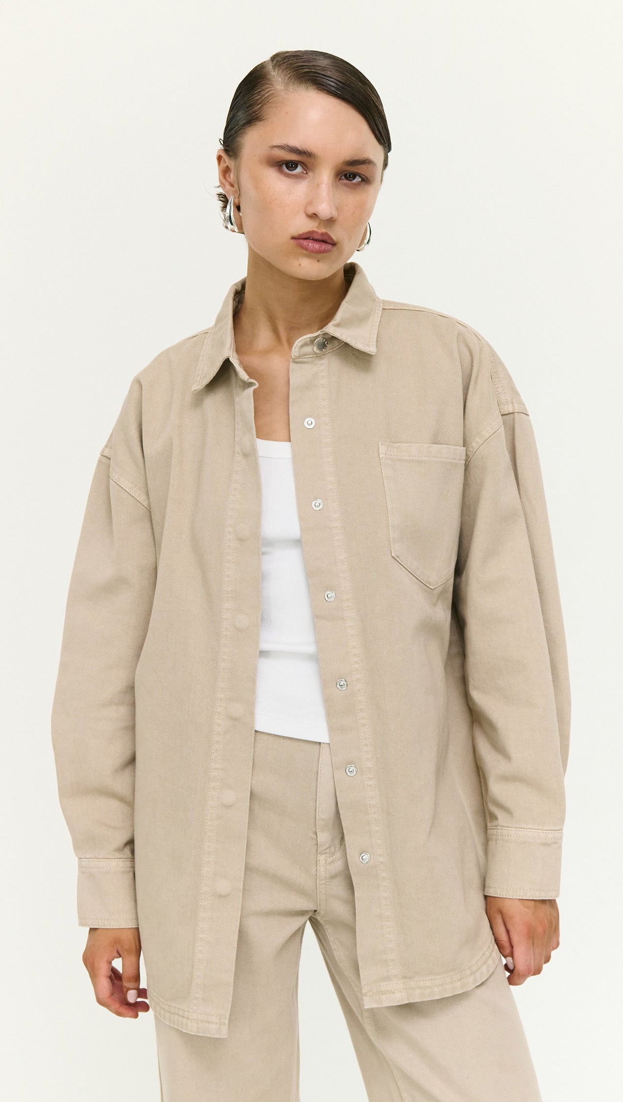 Stone Wash Relaxed Denim Shacket worn by a model, featuring a light beige color and relaxed fit, perfect for layering.
