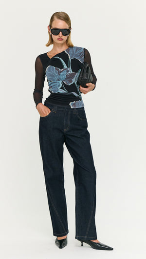 Woman wearing a Blue Floral Asymmetric Neck Mesh Top paired with dark jeans and stylish accessories.
