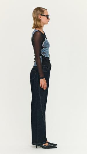 Model wearing a Blue Floral Asymmetric Neck Mesh Top with black jeans and sunglasses, showcasing a contemporary fashion look.