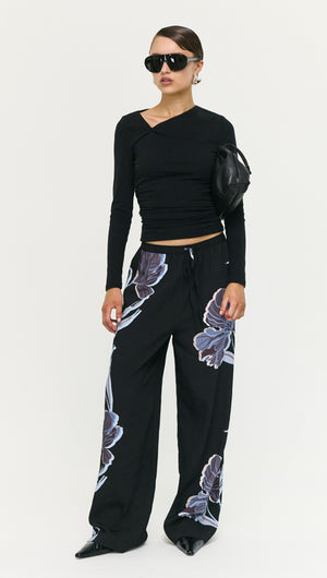 Model wearing Blue Floral Relaxed Drawstring Pant with black top and sunglasses, showcasing a stylish off-duty look.