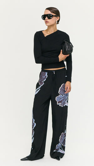 Model wearing Blue Floral Relaxed Drawstring Pant paired with a fitted black top and sunglasses, showcasing a chic off-duty look.