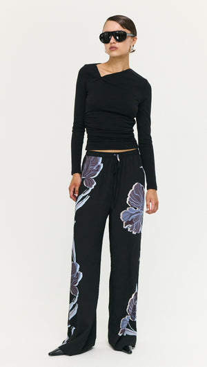 Model wearing Blue Floral Relaxed Drawstring Pant with a fitted black top and sunglasses, showcasing a stylish outfit.