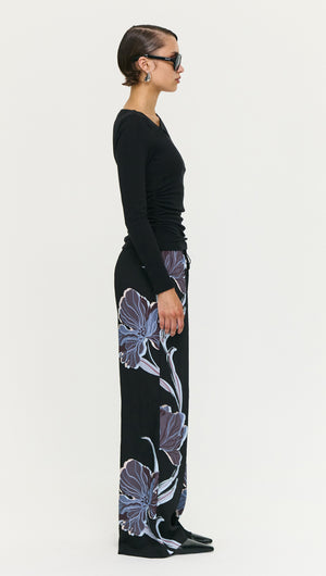 Side view of a model wearing Blue Floral Relaxed Drawstring Pant paired with a black long-sleeve top.