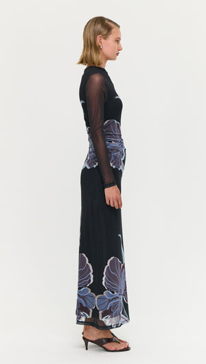 Side view of a model wearing a Blue Floral Mesh Midi Dress showcasing intricate floral patterns and sheer mesh sleeves.