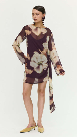 Sheer Floral Mini Dress with Tie Detail featuring a model wearing a trendy floral design in shades of purple.