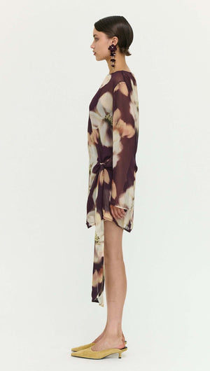Sheer Floral Mini Dress with Tie Detail modeled by a woman from the side, showcasing the elegant floral design and tie feature.