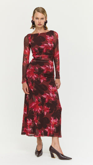 Model wearing a Ruched Pink Floral Mesh Midi Dress featuring long sleeves and a flowy design.