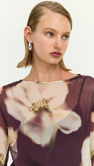 Model wearing a Sheer Floral Maxi Dress with Tie Detail featuring a deep floral print and elegant design details.