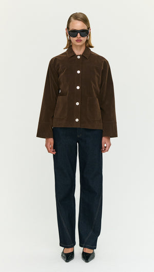 Model wearing a Chocolate Brown Faux Suede Barn Jacket styled with dark denim jeans and sunglasses.