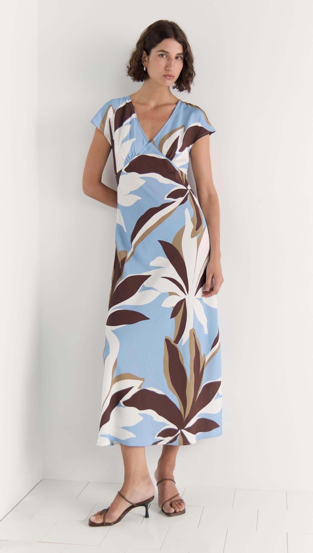 Maeve Midi Dress featuring a V-neckline, cap sleeves, and a flattering abstract floral print in brown, cream, and blue.