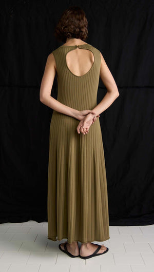 Back view of a woman in an olive-toned ribbed midi dress featuring a keyhole cutout and soft A-line silhouette.