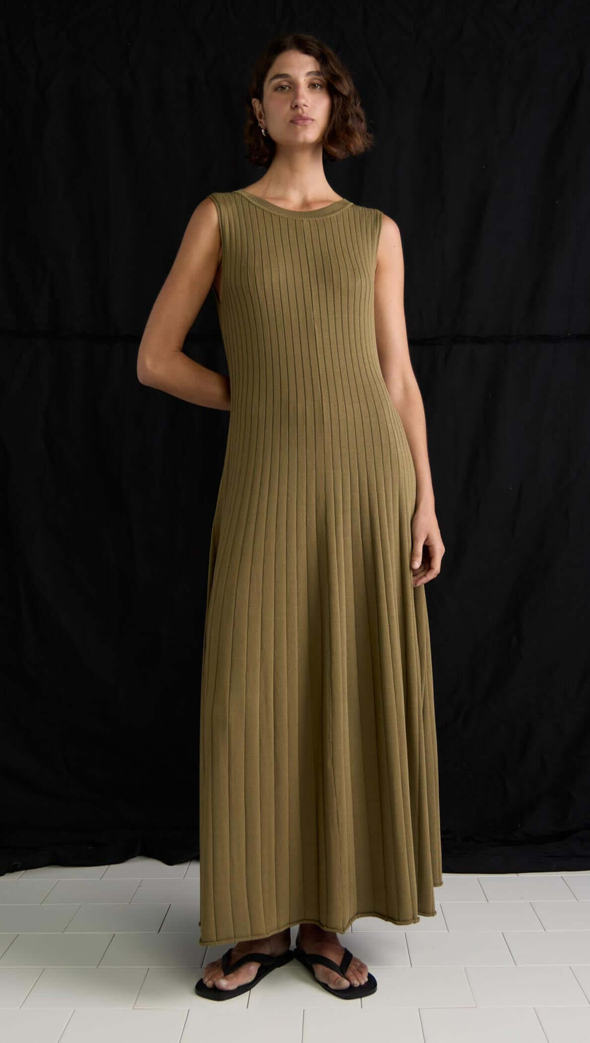 Olive-toned ribbed knit midi dress with sleeveless design and A-line silhouette.