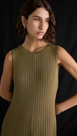 Model wearing olive-toned ribbed midi dress with sleeveless design and crew neckline, showcasing modern style.