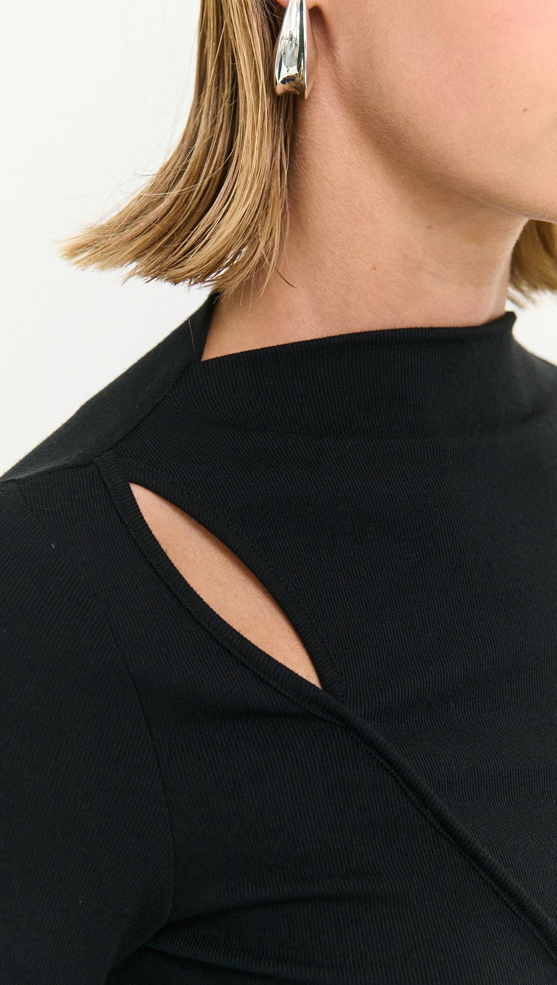 Model wearing a Black Asymmetric Seam Detail Midi Dress showcasing unique seam lines and a stylish cut-out detail.