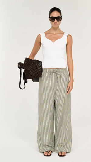 Model wearing a Sweetheart Rib Knit Tank in White and striped wide-leg pants, holding a black woven bag.