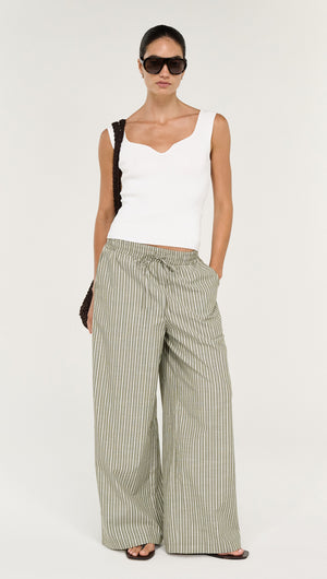 Model wearing Khaki Stripe Relaxed Cotton Pant with a white top and sunglasses, showcasing a stylish summer outfit.
