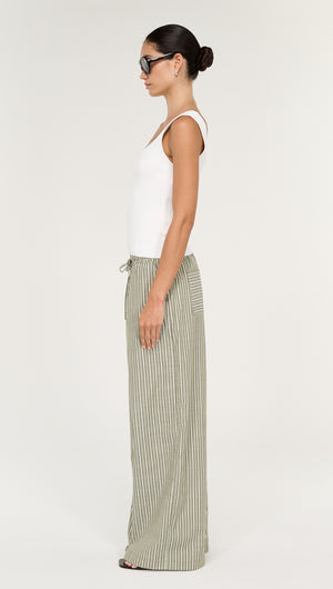 Model wearing Khaki Stripe Relaxed Cotton Pant, featuring a side view with a fitted top and stylish sunglasses.