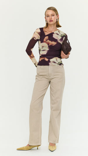 Model wearing a floral long-sleeve top with Stone Wash Straight Leg Jeans, holding a clutch purse.