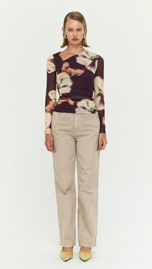 Model wearing floral long sleeve top with straight leg beige trousers and yellow heels.