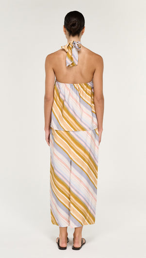 Woman wearing a pastel stripe mid rise midi skirt with a matching top, showcasing a stylish back view.