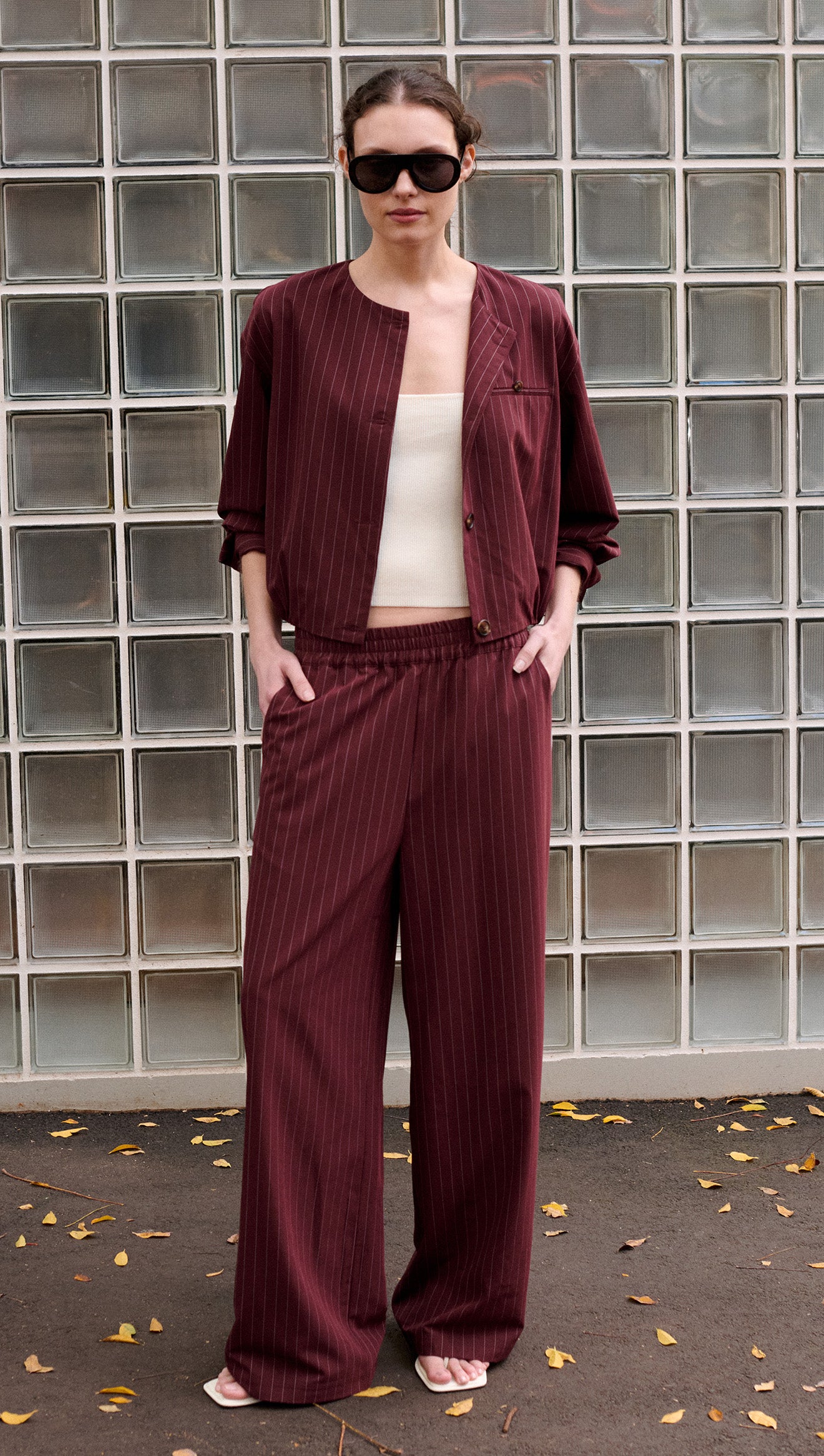 Model wearing a Burgundy Pinstripe Cropped Jacket with matching pants, showcasing modern tailoring and chic style.