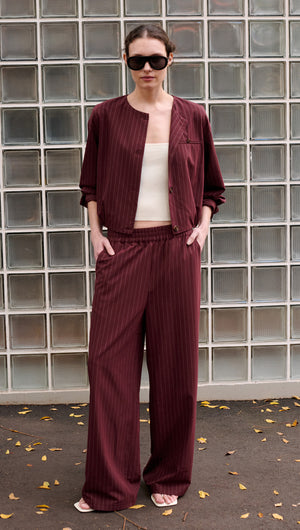 Model wearing a Burgundy Pinstripe Cropped Jacket with matching pants, showcasing modern tailoring and chic style.