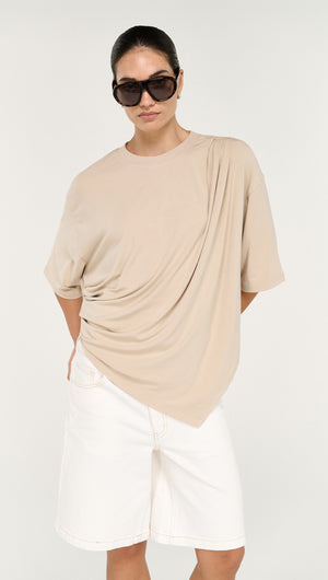 Asymmetric Draped Oversize Tee in Beige worn by a model, showcasing the unique draped design and stylish look.