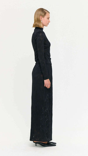 Model wearing a Black Sheer Lace Maxi Skirt, showcasing a side view of its elegant design and silhouette.