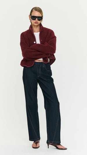Woman wearing a Burgundy High Neck Cropped Sherpa Jacket with black wide-leg jeans, showcasing a stylish winter look.