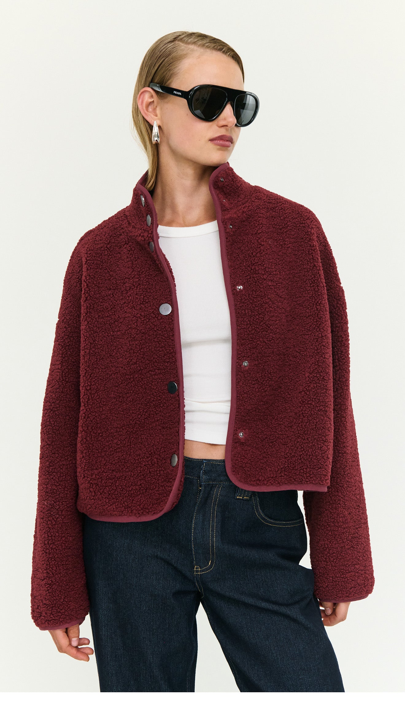 Burgundy High Neck Cropped Sherpa Jacket worn by model, styled with sunglasses and a white tank top, perfect for cool-weather layering.