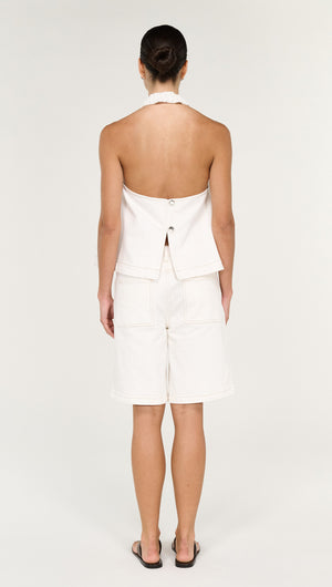 Back view of a model wearing a Cotton Denim Halter Top in White with matching shorts.