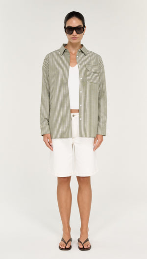 Model wearing a Khaki Stripe Cotton Oversized Shirt with white shorts and sunglasses on a neutral background.