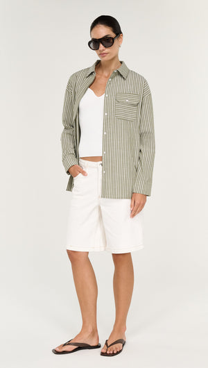Model wearing a Khaki Stripe Cotton Oversized Shirt with white shorts and sunglasses.