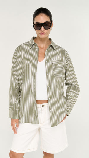 Model wearing Khaki Stripe Cotton Oversized Shirt with sunglasses and white shorts, showcasing a relaxed summer style.