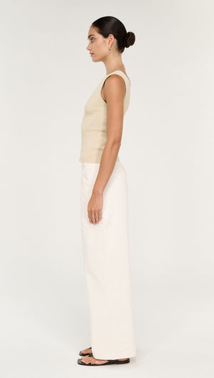 Model wearing the Fine Rib Knit Reversible Tank in Ecru, paired with wide-leg pants, showcasing a stylish side profile.