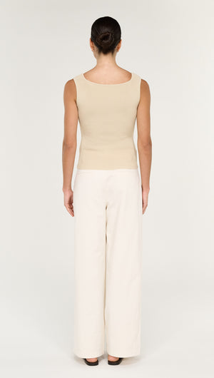 Back view of a model wearing the Fine Rib Knit Reversible Tank in Ecru paired with wide-leg trousers.