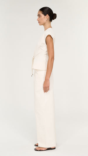 Model showcasing the Cotton Tie Front Top with Cap Sleeve, styled in light fabric, side view, paired with matching trousers.