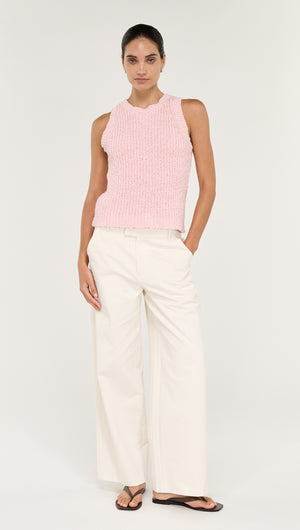 Model wearing a Cotton Blend Knit Tank in Soft Pink paired with wide-leg white pants.