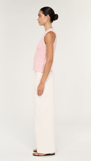 Model wearing a Cotton Blend Knit Tank in Soft Pink with white wide-leg pants, showcasing a side view of the outfit.