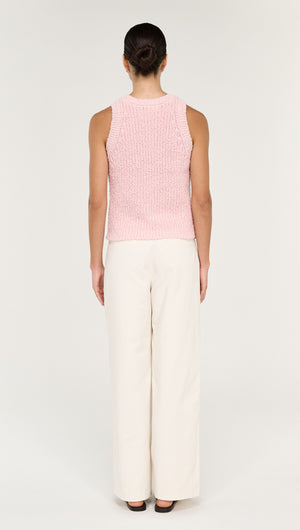 Back view of a model wearing a Cotton Blend Knit Tank in Soft Pink paired with cream wide-leg pants.