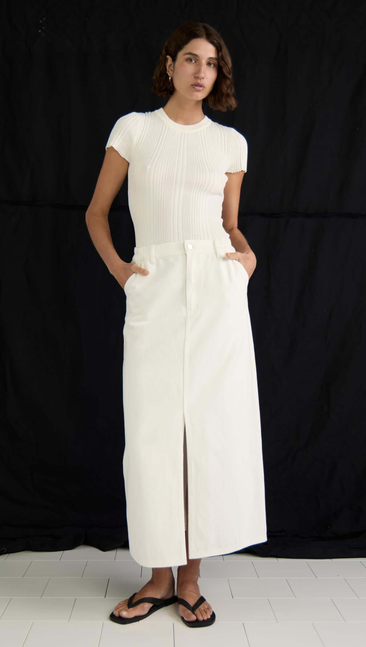 Model wearing the Emmie Denim Midi Skirt in off-white, featuring a centre front split and high-waisted design.