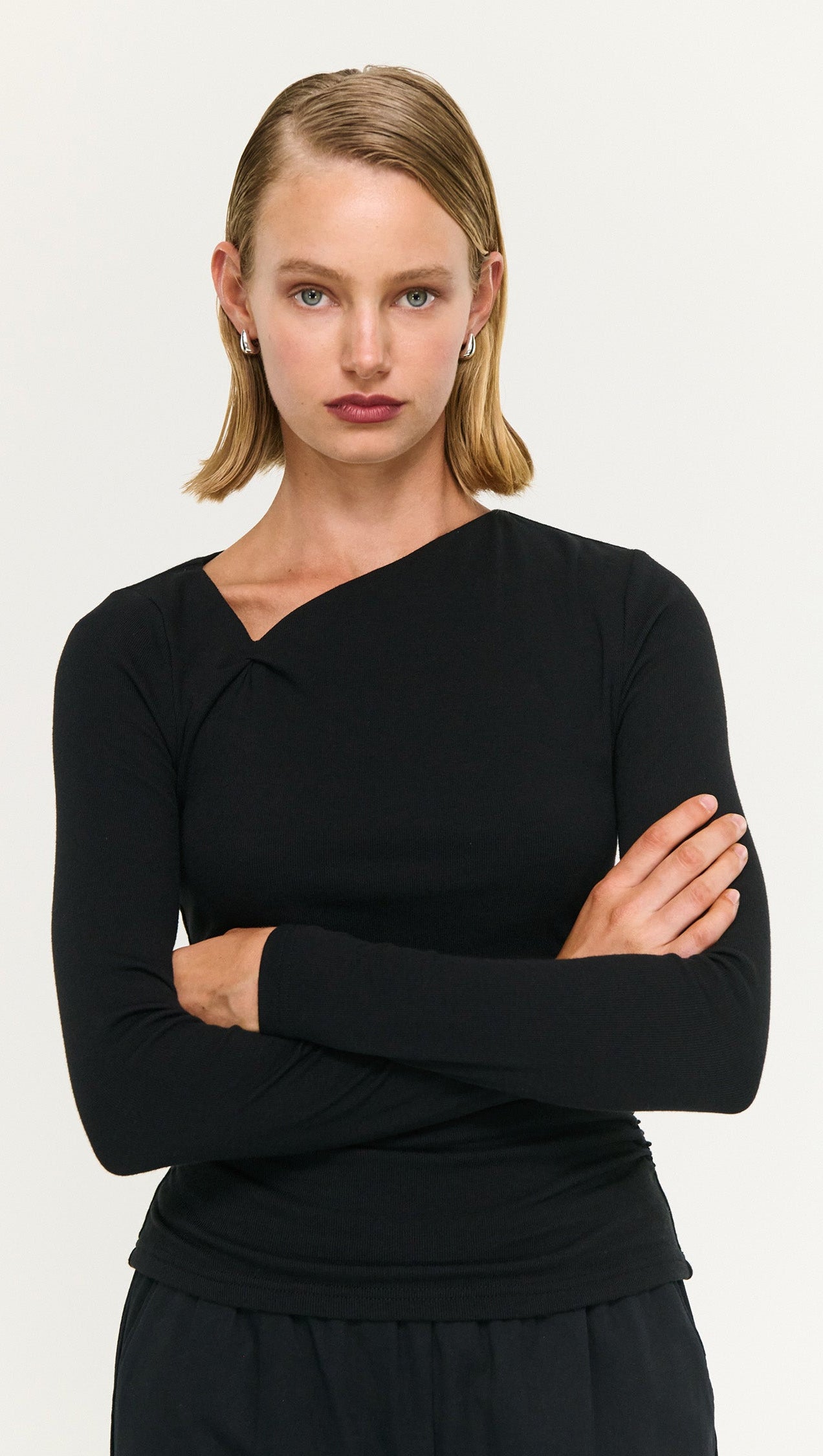 Model wearing a Black Soft Jersey Twist Neck Top showcasing its stylish design and soft stretch fabric.