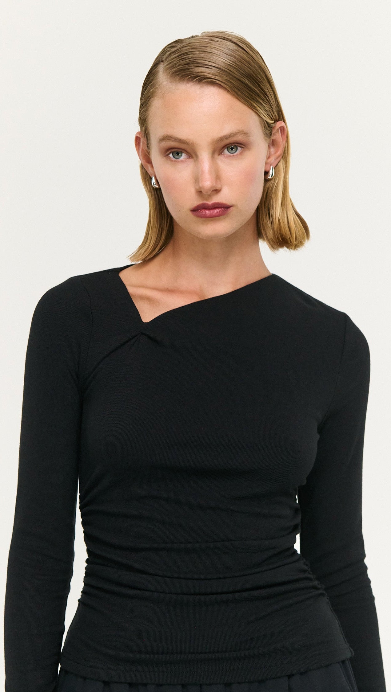 Model wearing a Black Soft Jersey Twist Neck Top showcasing its stylish design and soft stretch fabric.