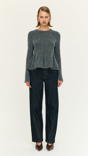 Soft Knit Peplum Top with Flute Sleeve styled with dark jeans, showcasing a feminine look.
